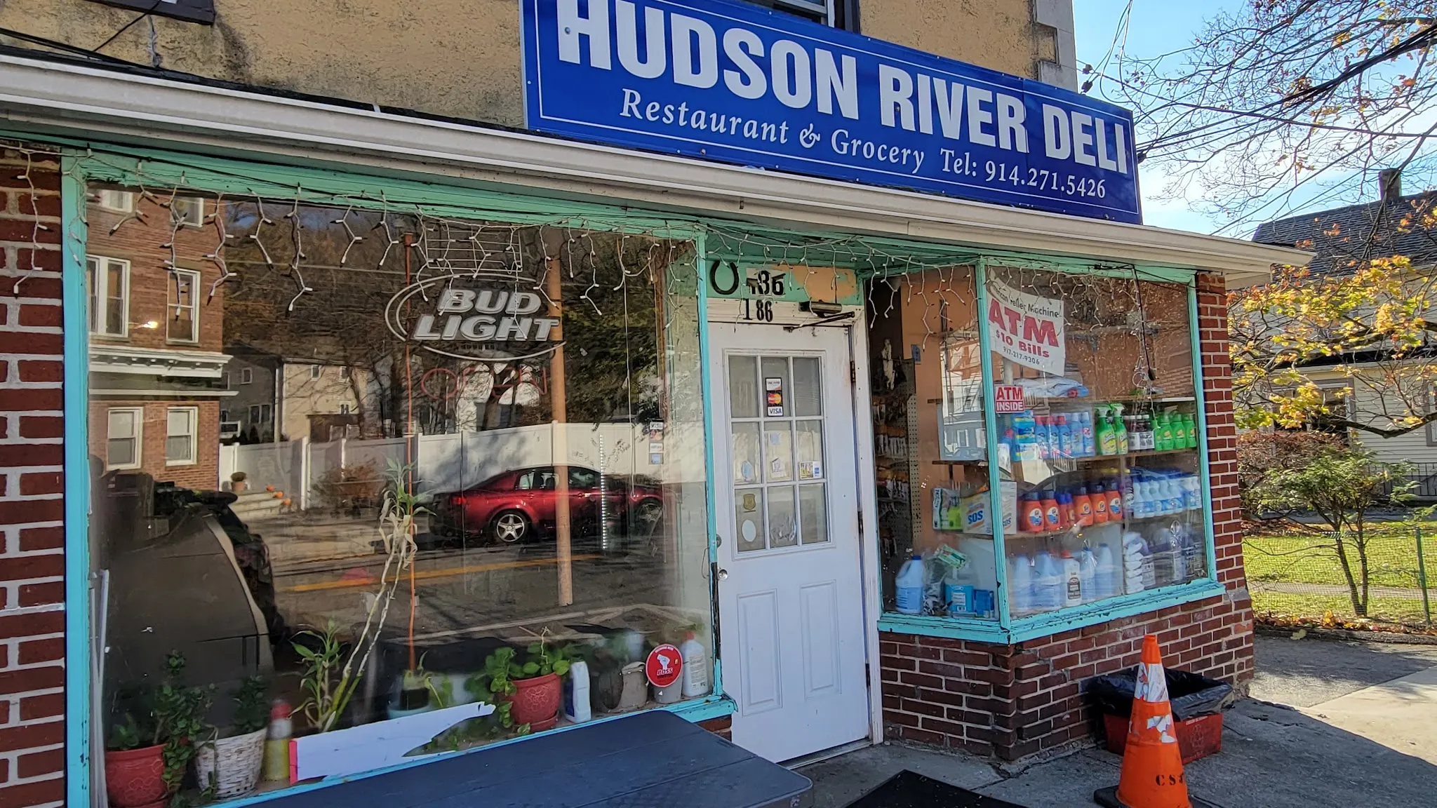 The Hudson River Deli storefront: a blue sign over aqua window frames and a white door marked 186
